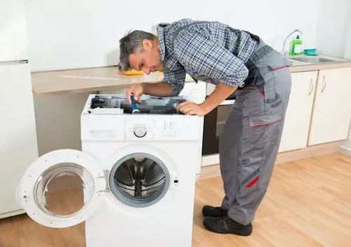 мастер ремонтирует стиральную машину